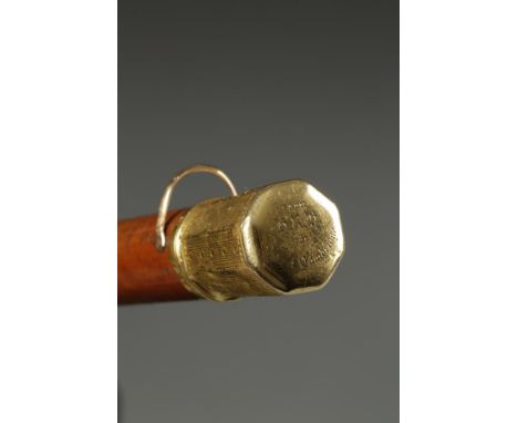 A GEORGE III GOLD MOUNTED WALKING CANE, the top mount with bright-cut and dot engraving, the top with engraved presentation i