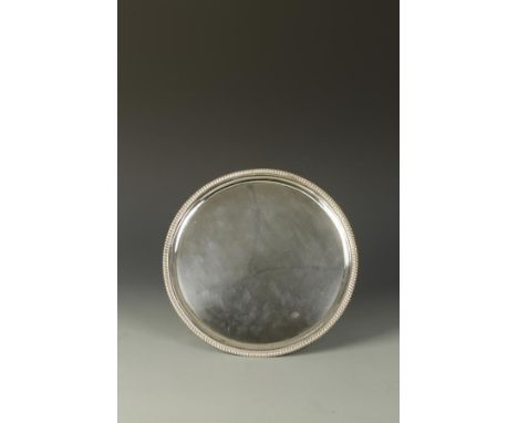 A VICTORIAN SALVER of circular form with a raised gadrooned border, on three bracket feet, by Charles Stuart Harris, London 1