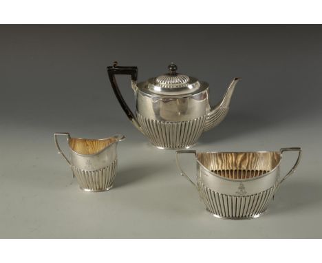 A MATCHED VICTORIAN AND LATER THREE PIECE TEA SET of oval form with reeded decoration, sugar bowl with a Masonic presentation