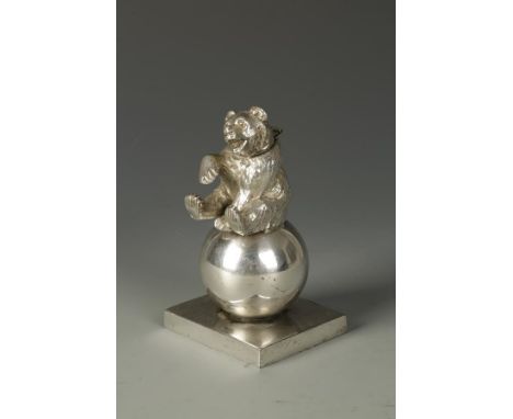 A NOVELTY ELECTROPLATED TABLE LIGHTER modelled in the form of a bear sitting on a ball, the hinged lid concealing a lighter, 