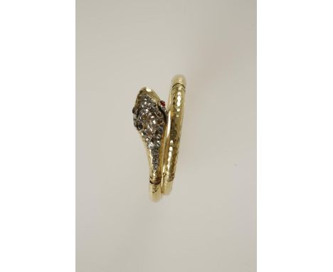 A GOLD AND DIAMOND SNAKE BANGLE, the coiled body of hammered surface, with five hinges, the head decorated with cushion-shape