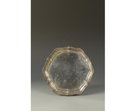 NAVAL INTEREST: A PRESENTATION SALVER of shaped circular form, with raised beaded border, on three ball and claw feet, the ce
