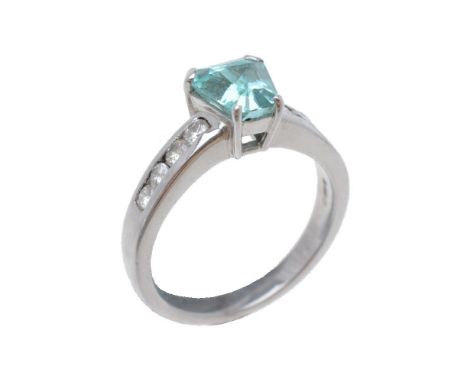 A tourmaline and diamond ring, the tapered step cut tourmaline within a four claw setting, to channel set brilliant cut diamo