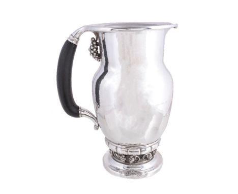 ϒGeorg Jensen, a Danish silver Grape pattern pitcher or jug, post 1945 stamped mark, design no. 407A, with an ebony handle, 2