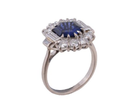 A sapphire and diamond panel ring, the central hexagonal cut sapphire, claw set within a surround of brilliant cut diamonds, 