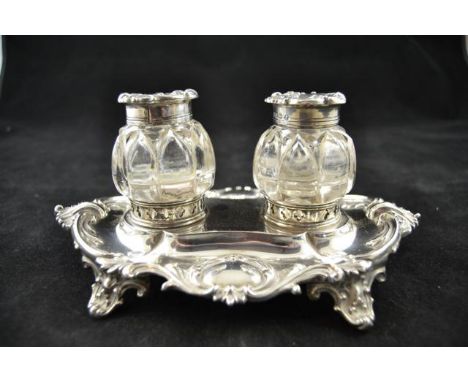 A Victorian embossed silver oval inkstand, foliate design with scroll feet, two glass bottles, Sheffield 1854, maker Henry Wi