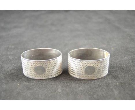 A cased pair of engine turned oval silver napkin rings, Birmingham 1925, maker F B Bros. - approx weight 45g/1.4 troy oz COND