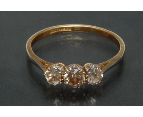 A diamond trilogy ring, central round old brilliant cut diamond approx 0.35ct, flanked either side by a smaller conforming di