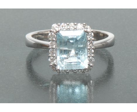 An aquamarine and diamond cluster ring, central rectangular emerald cut light blue aquamarine, approx 1.72ct, surrounded by a