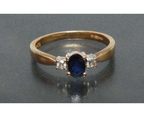 A sapphire and diamond trilogy ring, central oval blue sapphire, approx 0.70ct, flanked either side by a single round brillia