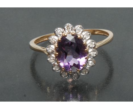 An amethyst and diamond cluster ring, central oval pinky purple amethyst approx 1.75ct, surrounded by a band of fourteen roun