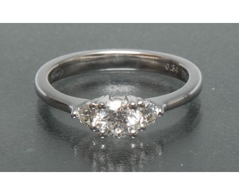 A diamond trilogy ring, central round brilliant cut diamond approx 0.25ct, flanked by a smaller conforming stone either side,