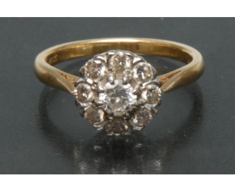 A diamond cluster ring. central round brilliant cut diamond approx 0.45ct, surrounded by a band of eight smaller conforming, 