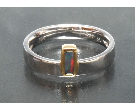 An 18k yellow gold Australian black opal cabochon ring, rectangular opal flashing vibrant red orange colour play, approx 0.20