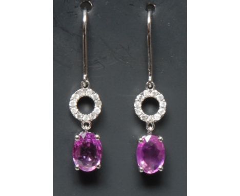 A pair of pink sapphire and diamond drop earrings, each with an oval cut pink sapphire terminal approx 0.83ct, suspended from