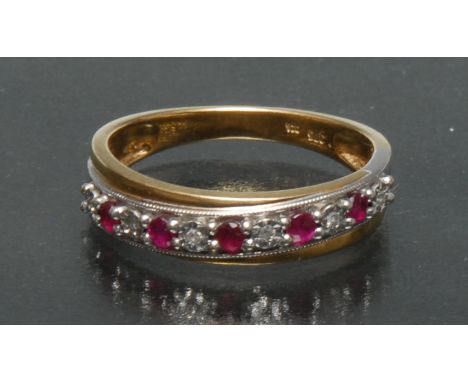 A ruby and diamond line ring, alternate set with six diamonds and five rubies, white and yellow metal cross over crest, 9ct g