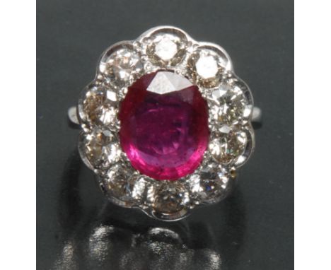 An impressive large diamond and ruby cluster ring, central large pinky red ruby, measuring approx 12.4mm x 9.7mm x 3.8mm, est