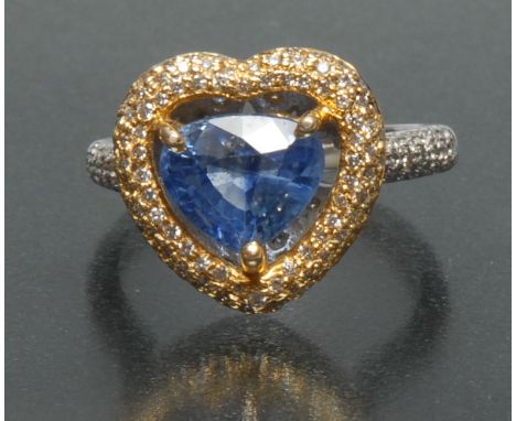 A diamond and sapphire heart ring, central pale blue sapphire surrounded by a yellow and white gold mount pave set with round