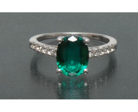 A synthetic emerald and diamond dress ring, central oval vibrant green synthetic emerald, approx 1.66ct, claw set above five 