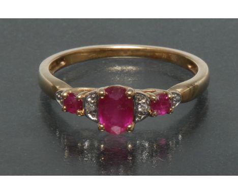 A ruby and diamond ring, central oval red ruby and two slammer pinky red rubies, each divided by a round brilliant cut diamon