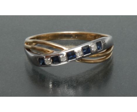 A sapphire and diamond cross over crest ring, top white gold arch linear inset with five princess cut square blue sapphires a