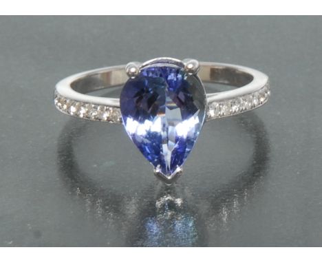 A tanzanite and diamond ring, central pear shaped vibrant purply blue tanzanite approx 2.30ct, claw set above a 14ct white go