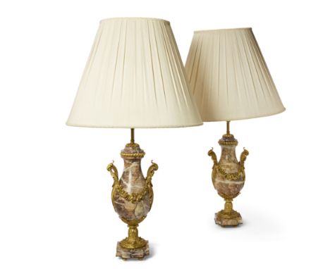A pair of French gilt-bronze mounted marble urn table lamps, 20th century, each with twin foliate handles hung with floral sw