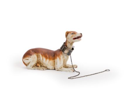 A Neapolitan polychrome wood creche model of a recumbent hound, 19th century, inset with glass eyes, with a silver collar and