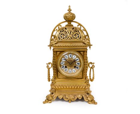 A French gilt-bronze mantel clock, late 19th century, with foliate finial above pierced top with scrolling foliage and mask, 