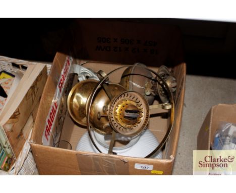 A brass oil lamp with cast metal base and a brass oil lamp with opaque glass shade