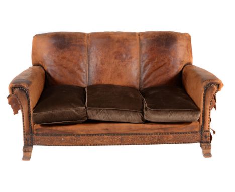 
	
		A suite of leather upholstered seat furniture, circa 1920, comprising; a two seat sofa, with embossed grape and vine fri