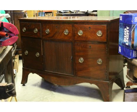 Early 19th century Mahogany Bow Front Sideboard with an arrangement of three drawers over a central cupboard with tambour doo