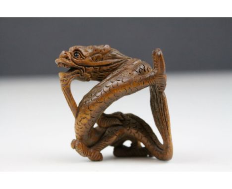 Signed carved wooden netsuke in the form of a dragon with glass eyes