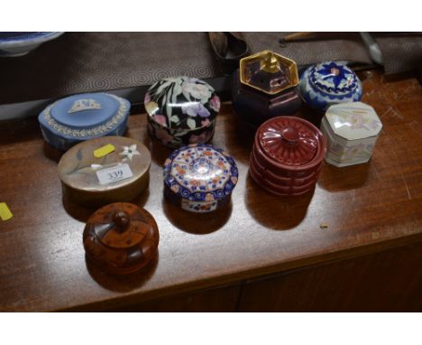 A collection of small trinket boxes and vases and covers