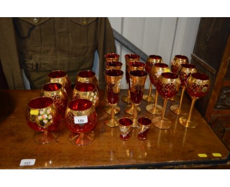 Three sets of six each Murano ruby and gilt decorated drinking glasses and two matching shot glasses