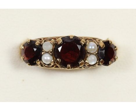 A 9ct gold garnet and cultured pearl three stone ring, carved claw set, M 1/2, 2.7gm 