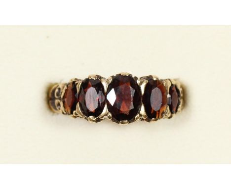 A 9ct five stone garnet ring, carved claw set, N, 3.4gm 
