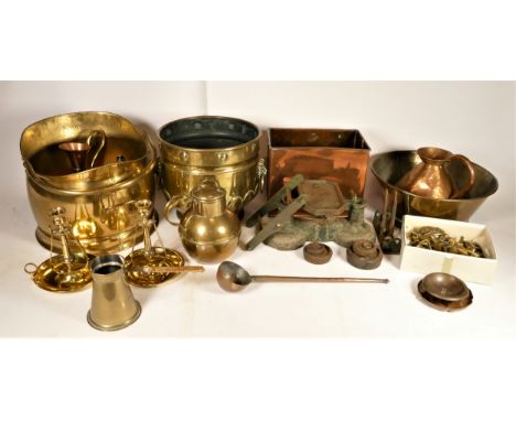 A collection of brass and copper wares to include a coal helmet, mixing bowl, pair of candle sticks, tankards, measures and c