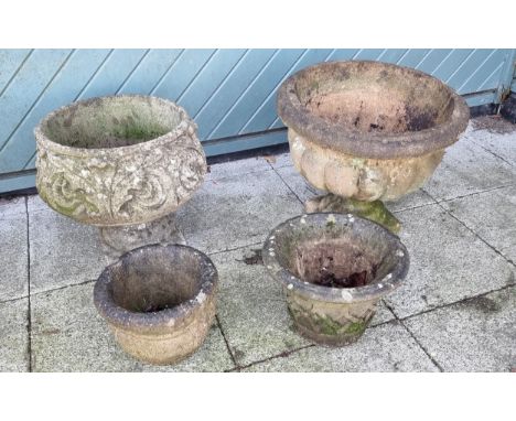 A concrete planter with floral decoration, diameter 46cm and a fluted example, diameter 54cm, together with two smaller examp