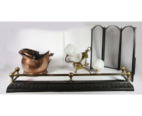 A cast metal &amp; brass fire curb, together with a copper coal helmet, a three fold fire screen, irons, and a three branch b