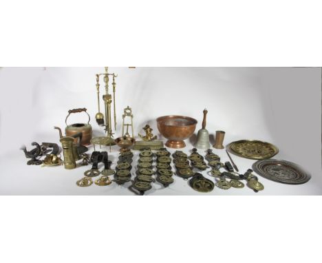 A collection of brass and copper wares, to include horse brasses, candle sticks, bell weights, chamber sticks, fire irons, ci