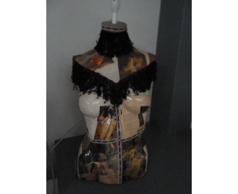 A half torso mannequin lamp decorated with poetry and pictures  embellished with black fringing 70cmH