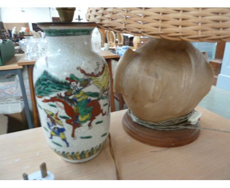 A Chinese ceramic lamp base, decorated with riders, with another skin lamp