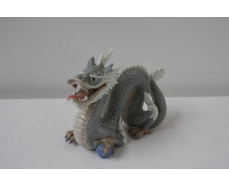 A ceramic blue Chinese dragon figurine holding a blue ball in its claws, 15cmH