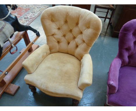 A 20th century Victorian style button back tub chair in gold material and turned legs