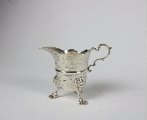 A good quality 18th Century Irish silver Milk Jug, c. 1755 of helmet form with embossed decoration on lions mask feet with sh
