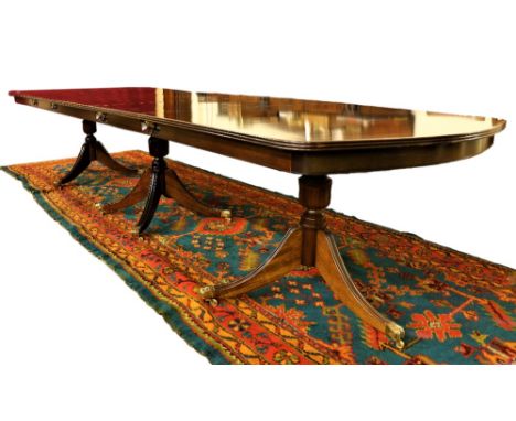 An attractive George III style mahogany triple pod Dining Table, with two spare leaves by O'Connells of Cork, the reeded edge