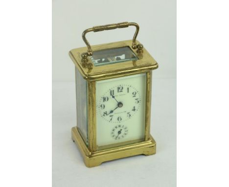 A 19th Century brass French Carriage Clock, open escapement and swivel carrying handle, with cream dial, supplied by Carl Leu
