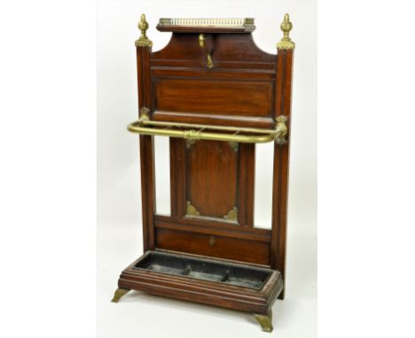 An Edwardian oak Stick and Umbrella Stand, by Jas. Shoolbred, with brass finials and pierced gallery on brass bracket feet. (