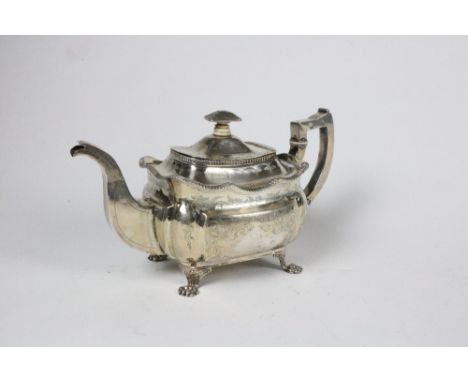 An elegant engraved Irish silver Teapot, of bulbous rectangular shape, with box handle and spout, on four decorated paw feet,